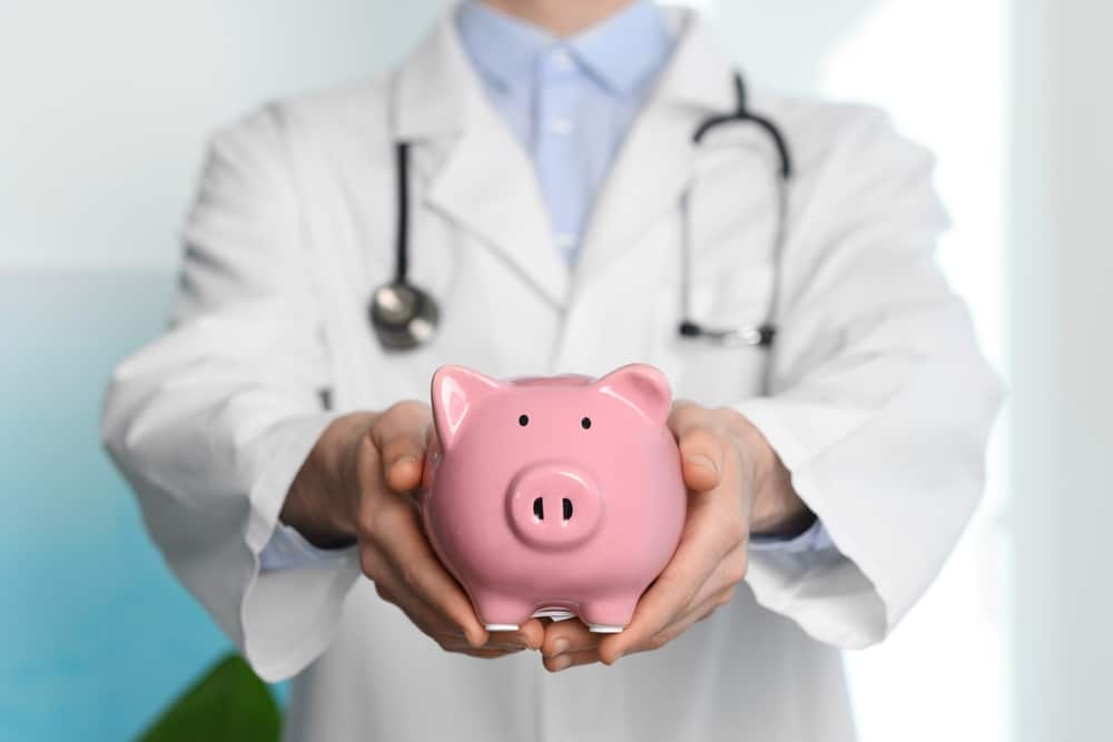 Doctor,With,Piggy,Bank,In,Hospital,,Closeup